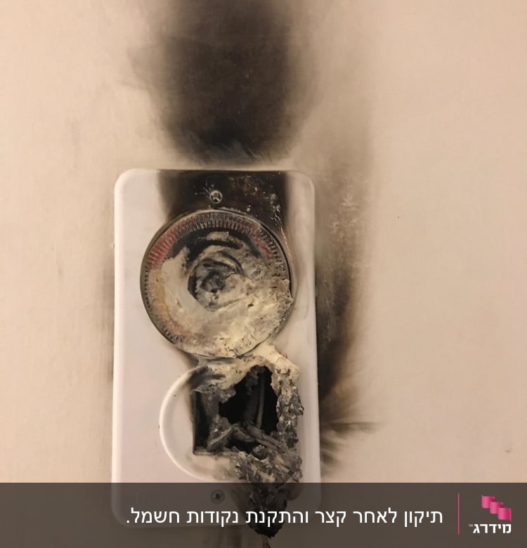 שקע חשמלי שרוף עם סימני פיח על הקיר